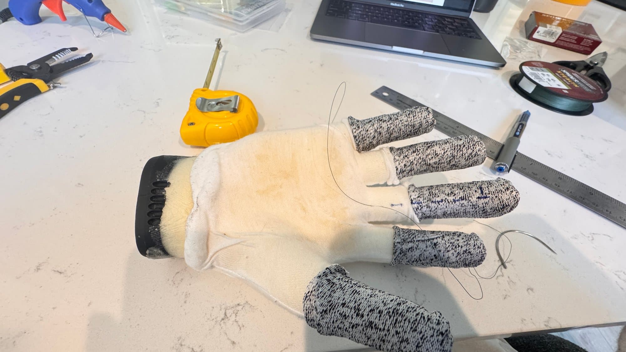 The glove with cut-resistant sleeves, needle, and braided fishing line