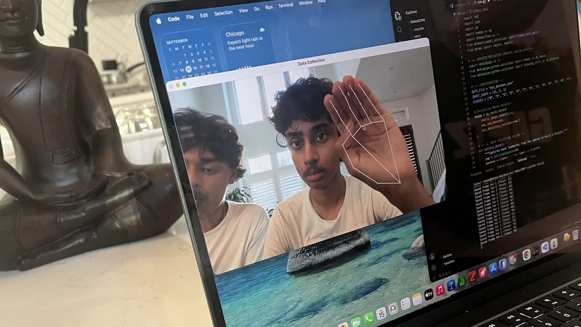 The data collection window on a laptop, with the hand landmark skeleton drawn over a raised hand